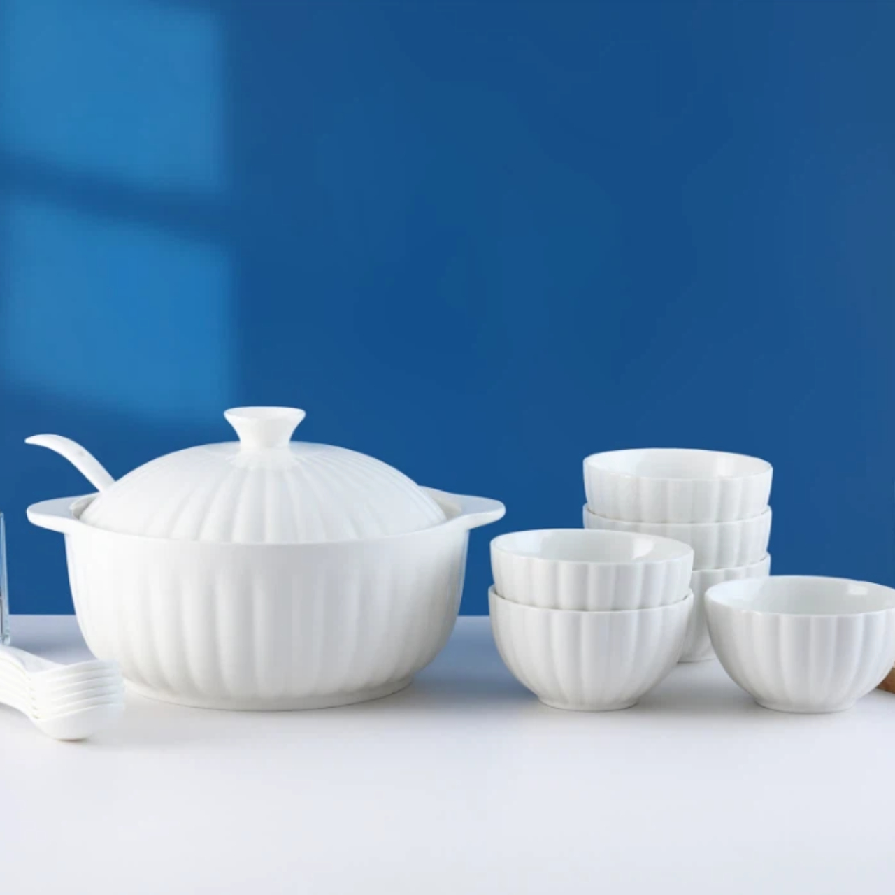 В набор с объемной текстурой входят суповая кастрюля с крышкой и двумя ручками, а также соответствующие миски и ложки.