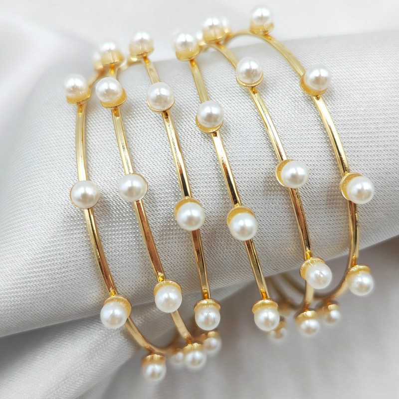 Изящные металлические кольца в сочетании с нежными жемчужными серьгами