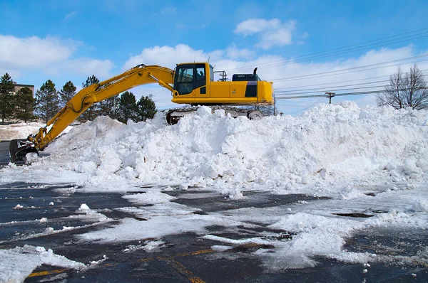 excavator clears snow